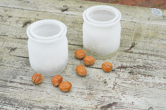 a couple of white vases sitting on top of a wooden table
