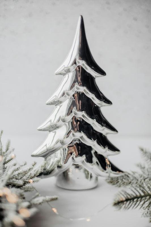 A silver christmas tree sitting on top of a table