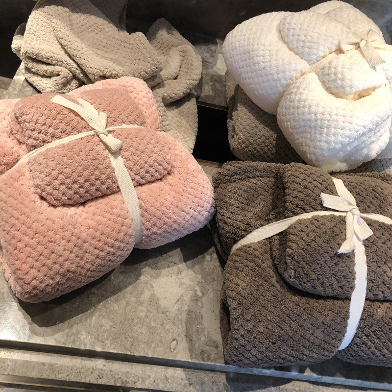 Ultra-Absorbent Coral Fleece Bath & Hand Towel Set in pink, white, brown, and beige, neatly folded and tied with ribbons.