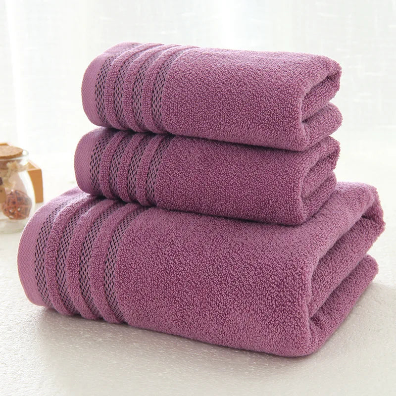 Stack of folded purple striped cotton towels on a bathroom shelf.