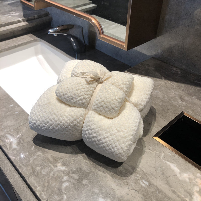 Ultra-Absorbent Coral Fleece Bath & Hand Towel Set in Pineapple Grid Collection, neatly arranged on a marble countertop.