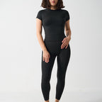 Seamless 2-Piece Activewear Set featuring a short sleeve sport t-shirt and long leggings in black, modeled by a woman.