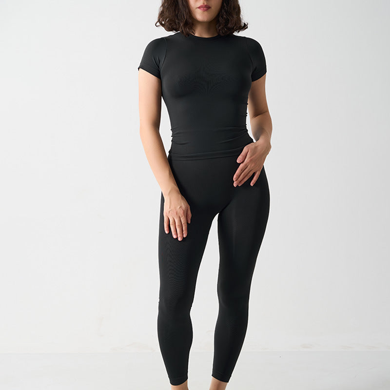 Seamless 2-Piece Activewear Set featuring a short sleeve sport t-shirt and long leggings in black, modeled by a woman.