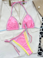 Close up of scalloped shell-edge detail on pink swimwear.