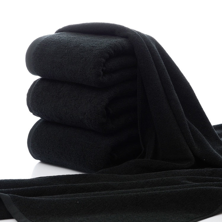 Luxury 100% Cotton Black Terry Bath & Face Towels stacked neatly, showcasing their soft texture and rich color.