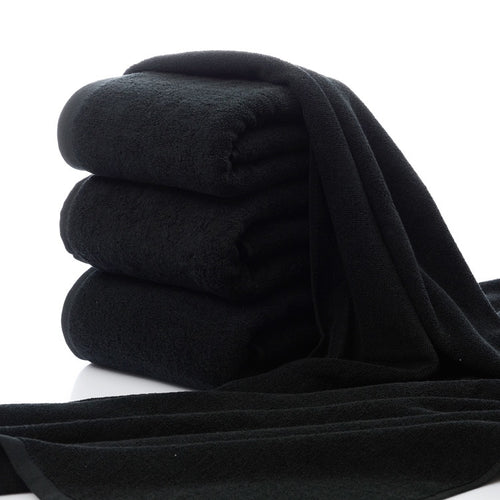 Luxury 100% Cotton Black Terry Bath & Face Towels stacked neatly, showcasing their soft texture and rich color.
