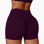 High-Waisted Tummy Control Yoga Shorts in deep purple with ruched detailing for a flattering fit. Ideal for fitness activitie