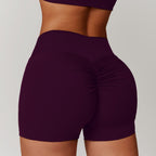 High-waisted tummy control yoga shorts in deep purple with ruched detailing for a flattering fit. Ideal for fitness activitie
