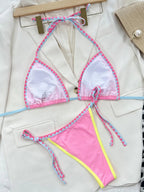 Woman wearing pink 2-piece swimsuit with boy short bottoms.