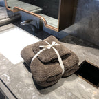 Ultra-Absorbent Coral Fleece Bath & Hand Towel Set in Pineapple Grid Collection, neatly stacked with a ribbon on a marble cou