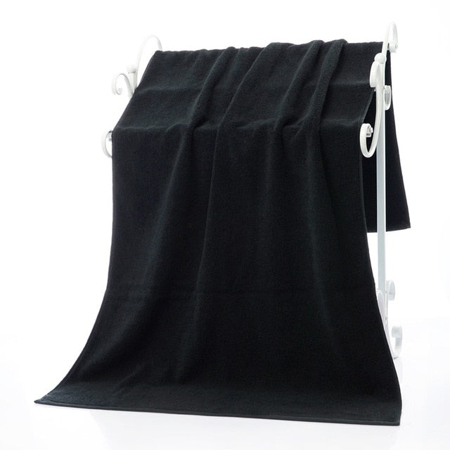 Luxury 100% Cotton Black Terry Bath & Face Towels displayed on a white towel rack, showcasing their soft texture and elegant 