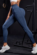 Front view of dark blue high-waisted active leggings on a model.