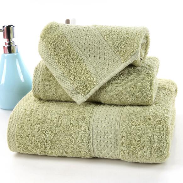 3-Piece Premium 100% Cotton Bath & Hand Towel Set in soft green, featuring textured patterns, stacked with a blue soap dispen