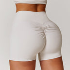 High-waisted tummy control yoga shorts in peach, designed for fitness with a flattering lift and ruching detail.