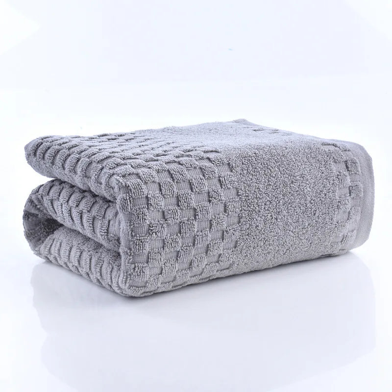 Premium Bamboo Charcoal Coral Velvet Bath Towel in gray, ultra-absorbent, folded with textured design, part of spa collection