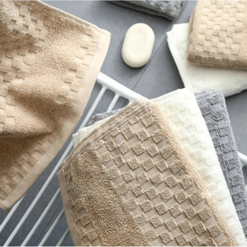 Premium Bamboo Charcoal Coral Velvet Bath Towels in various colors, displayed on a drying rack with a soap bar.
