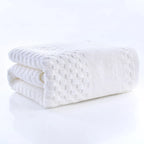 Premium Bamboo Charcoal Coral Velvet Bath Towel in white, ultra-absorbent, folded with textured pattern, part of spa collecti